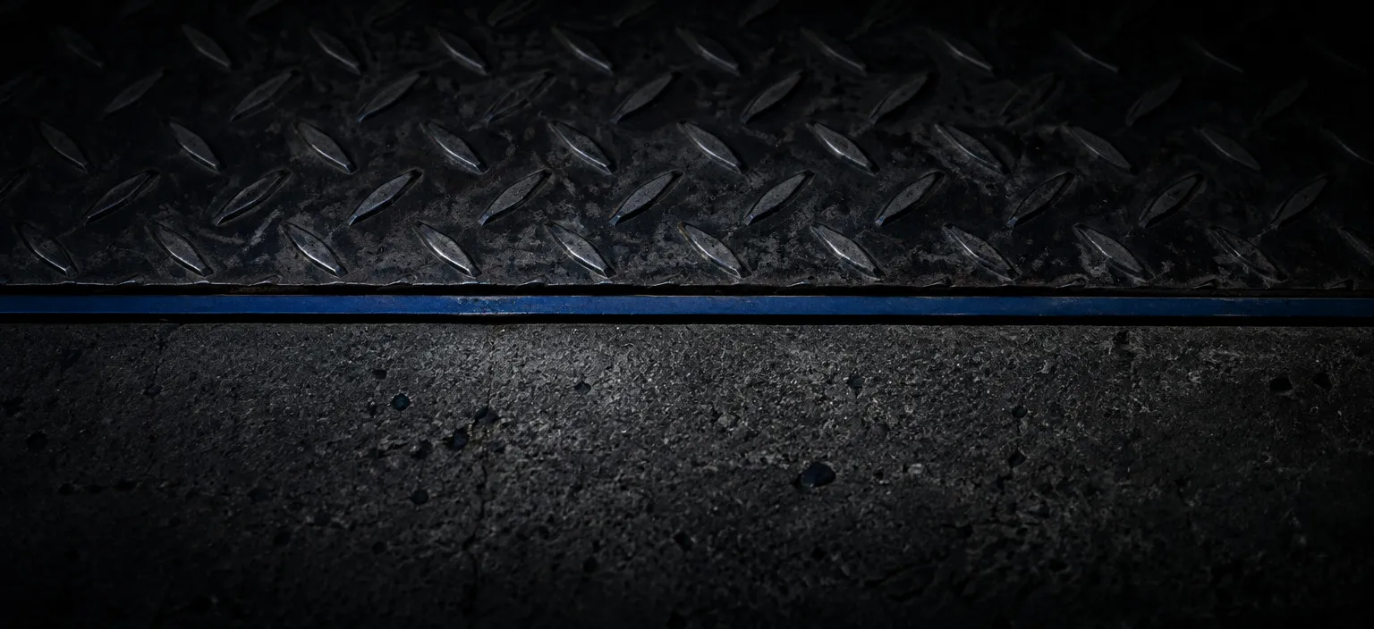A crisp expansion joint where a concrete floor meets a steel deck, forming one clean line